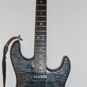 Warmoth Edel Strat

Stratocaster aus Warmoth Teilen. Der Korpus ist aus Esche mit einem sehr schönen Riegelahorn Furnier. Leider hat Warmoth keinen so tollen Lack benutzt. Die Gitarre war nämlich eigentlich mal *richtig* blau. Jetzt ist es eher ein graublau geworden mit Tendenz ins mausgrau. Der Hals ist wunderschön, deshalb gibts dafür nochmal ein eigenes Bild.
Sperzels, Fender LSR Rollernut, 6100er Bünde, Ebenholz Griffbrett, Suhr V60 Pickups, Wilkinson Bridge, Fender No-Load Tonpoti.