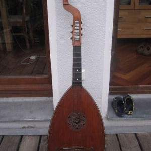 Deutsche Basslaute
Gitarrenlaute/Theorbe ca. 1900

Restaurationsobjekt.

Ein ehemals sicherlich hochwertiges Instrument. Leicht gekehltes Griffbrett aus Ebenholz, Wirbel der Mechaniken aus poliertem Stein.

Zustand ist kritisch. Statik des Korpus ist desolat. Multiple Risse und Spalten in Decke, Zarge und Boden, gelöste/offene Spanverleimungen, Decke im unteren Bereich vom Korpus gelöst. Die äusserst fein gearbeitete, aus der Decke geschnitzte Schallochrosette ist vielfach gerissen, aber noch intakt und komplett.

Falls jemand genauere Informationen zu diesem Instrument, seiner Geschichte, dem Baujahr oder dem Hersteller sagen kann, bitte unbedingt bei mir melden!