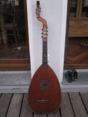 Deutsche Basslaute
Gitarrenlaute/Theorbe ca. 1900

Restaurationsobjekt.

Ein ehemals sicherlich hochwertiges Instrument. Leicht gekehltes Griffbrett aus Ebenholz, Wirbel der Mechaniken aus poliertem Stein.

Zustand ist kritisch. Statik des Korpus ist desolat. Multiple Risse und Spalten in Decke, Zarge und Boden, gelöste/offene Spanverleimungen, Decke im unteren Bereich vom Korpus gelöst. Die äusserst fein gearbeitete, aus der Decke geschnitzte Schallochrosette ist vielfach gerissen, aber noch intakt und komplett.

Falls jemand genauere Informationen zu diesem Instrument, seiner Geschichte, dem Baujahr oder dem Hersteller sagen kann, bitte unbedingt bei mir melden!