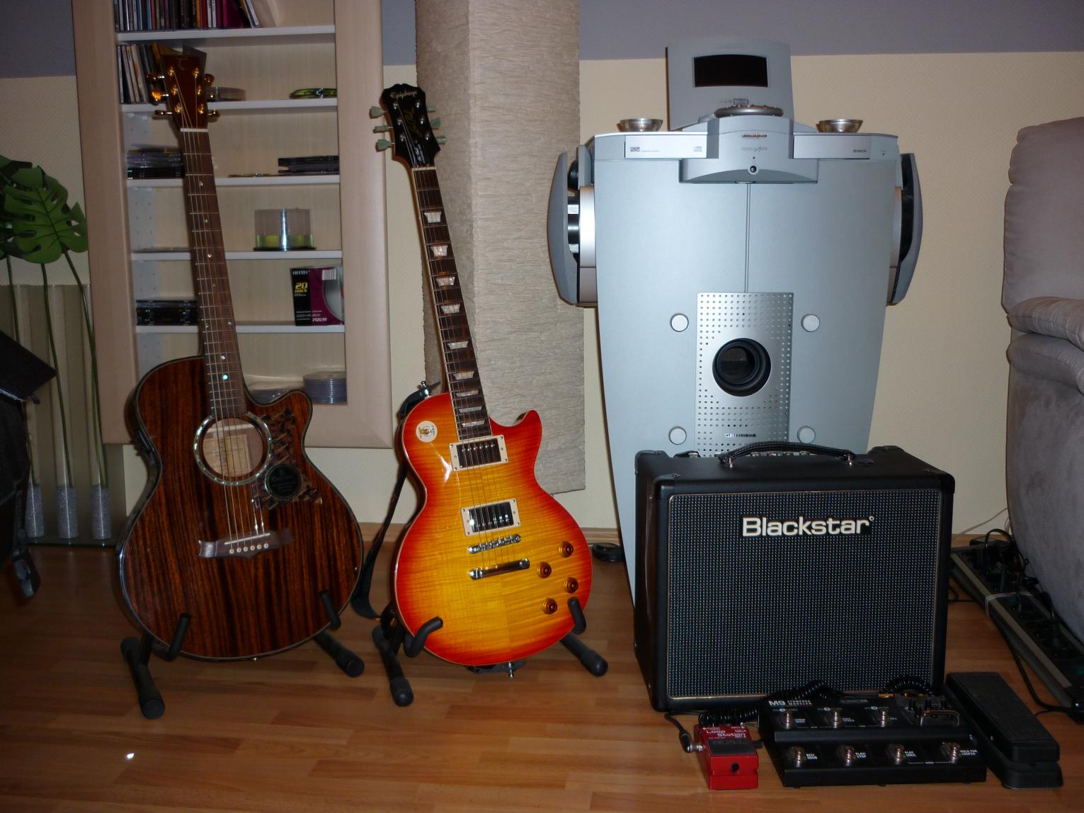 Übungsecke
-Tanglewood TW 45B
-Epiphone Les Paul Custom 1959 (mit kompletter Gibson Hardware)
-Blackstar HT5
-Boss RC2
-Line6 M9
-Cry Baby 95
-Das große Ding im Hintergrund ist eine Stereo Anlage :-)