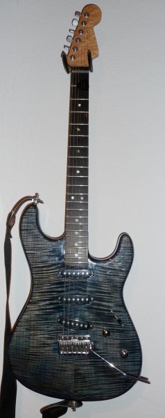 Warmoth Edel Strat

Stratocaster aus Warmoth Teilen. Der Korpus ist aus Esche mit einem sehr schönen Riegelahorn Furnier. Leider hat Warmoth keinen so tollen Lack benutzt. Die Gitarre war nämlich eigentlich mal *richtig* blau. Jetzt ist es eher ein graublau geworden mit Tendenz ins mausgrau. Der Hals ist wunderschön, deshalb gibts dafür nochmal ein eigenes Bild.
Sperzels, Fender LSR Rollernut, 6100er Bünde, Ebenholz Griffbrett, Suhr V60 Pickups, Wilkinson Bridge, Fender No-Load Tonpoti.